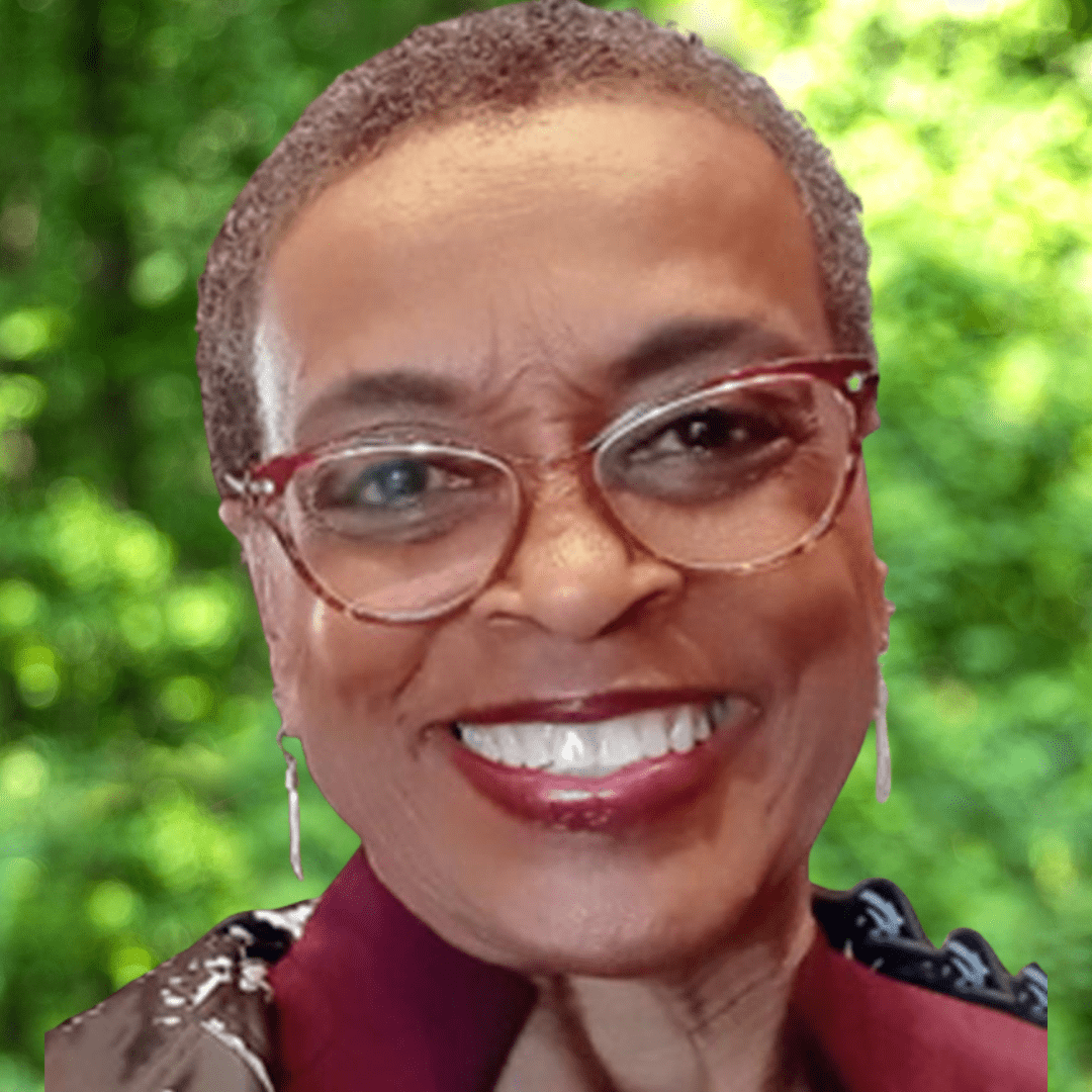 Headshot of Delegate Cheryl Pasteur. Woman smiling with short hair and read and brown shirt. 
