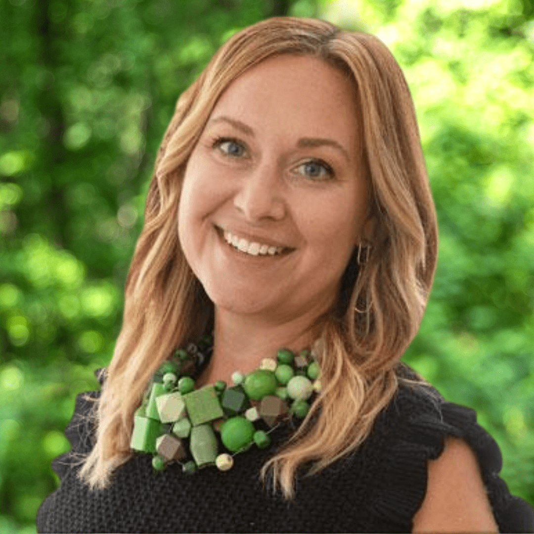 Emily Sollenberger Dobbins headshot. Woman with long brown hair smiling and wearing a black top and green necklaces.